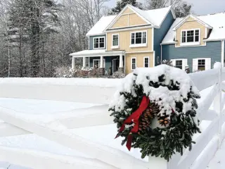 wreath on the corner of fence with view to exterior of Pantry Hill dusted in snow