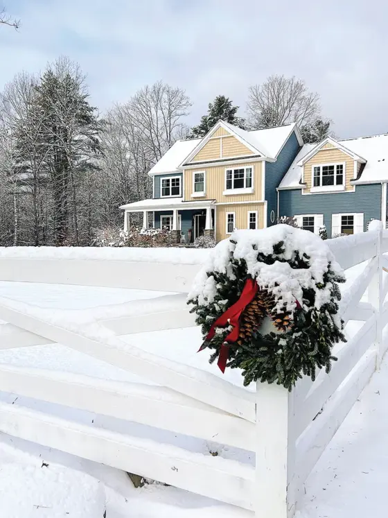 wreath on the corner of fence with view to exterior of Pantry Hill dusted in snow