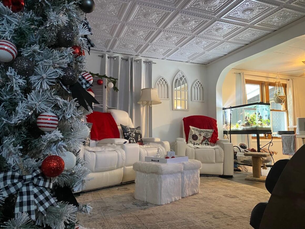 A living room with a Christmas tree and decorative ceiling tiles