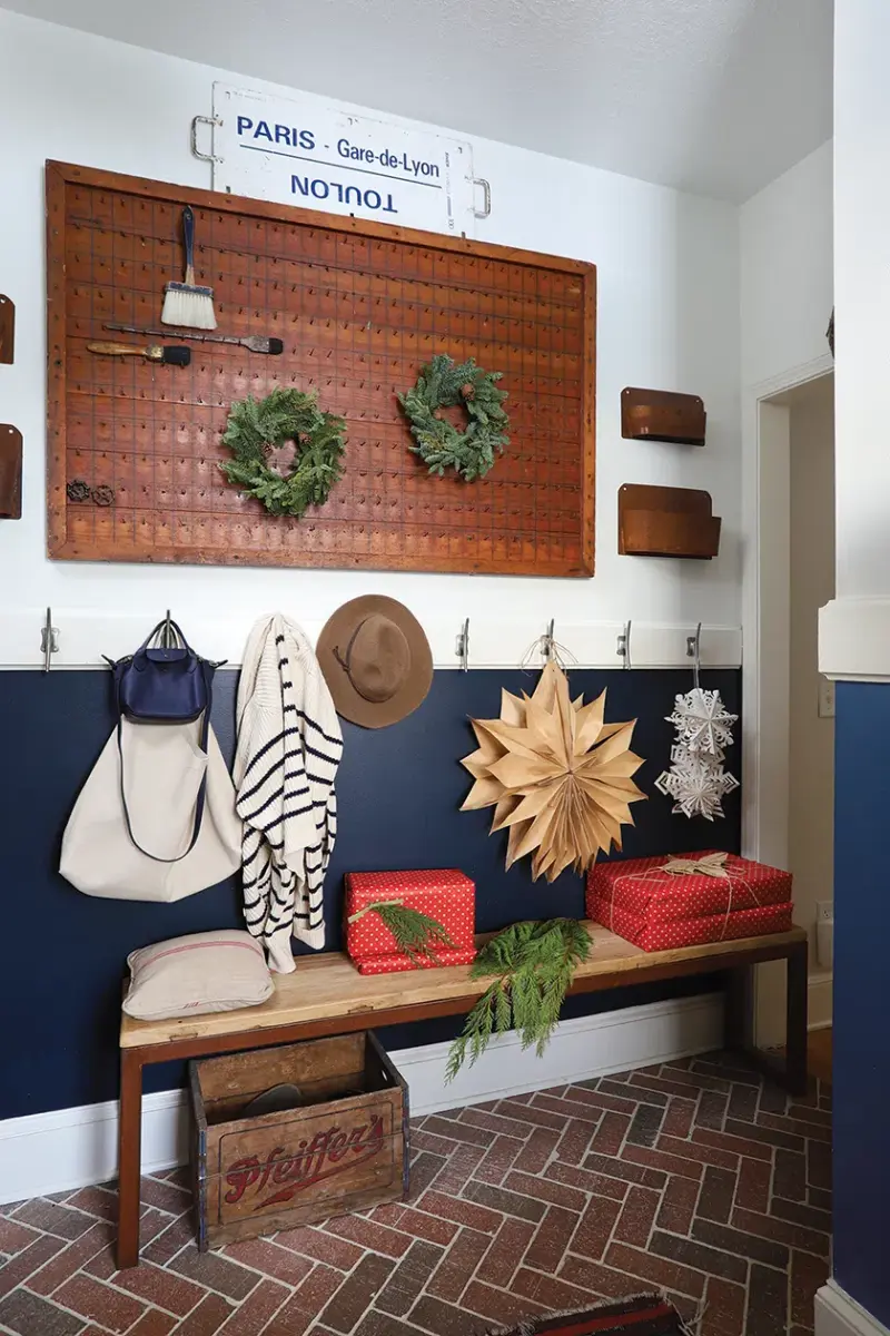 paper snowflakes and small wreaths on vintage pegboard in entryway of Michigan home decorated for the holidays