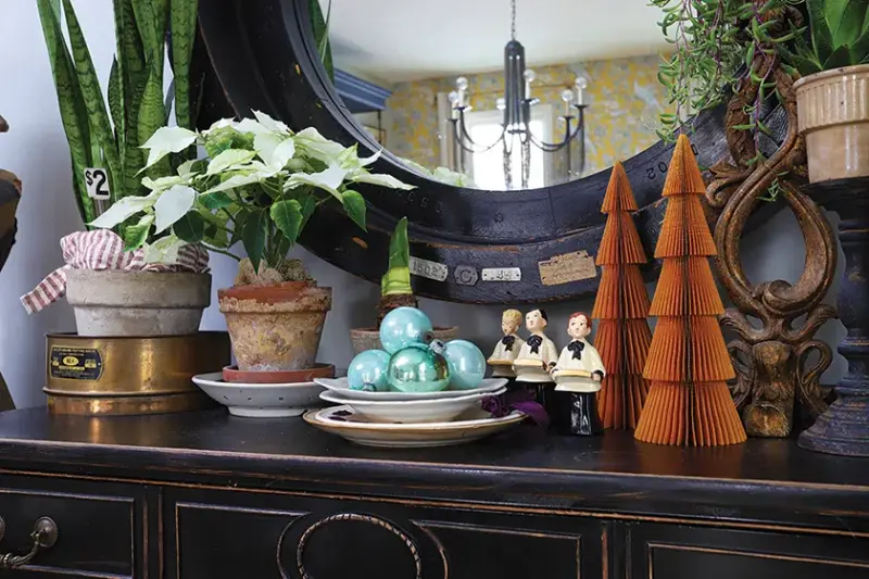 blue ornaments and vintage choir figurines next to accordion brown paper trees