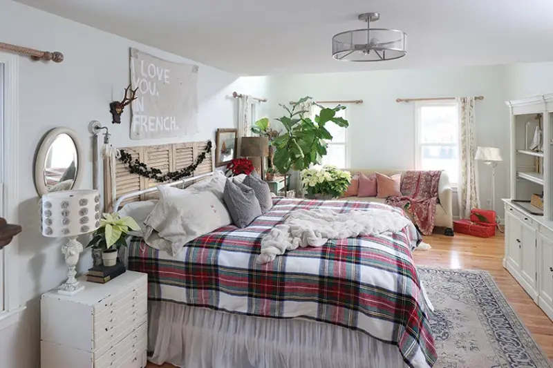 bedroom of home with natural holiday decorations with red and white poinsettias