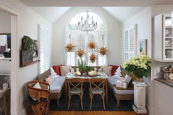 homemade paper snowflakes hang in window of curated holiday home with vintage and new collections