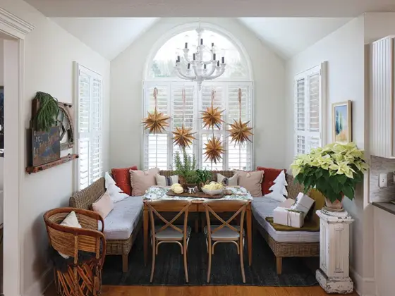 homemade paper snowflakes hang in window of curated holiday home with vintage and new collections