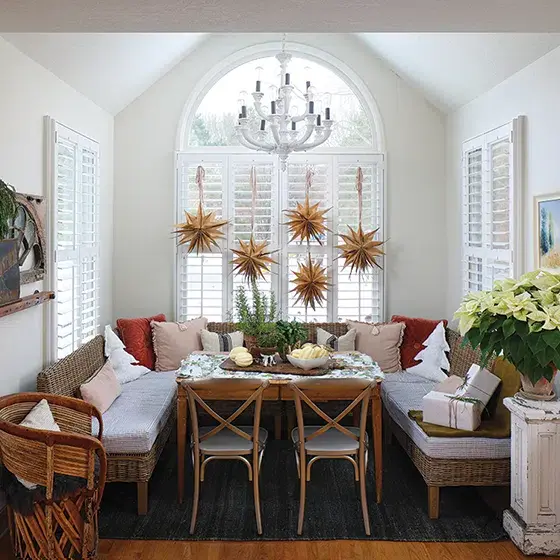 homemade paper snowflakes hang in window of curated holiday home with vintage and new collections