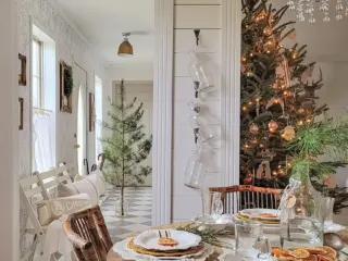 dining area with view to Christmas tree deocrated with lights and neutral ornaments