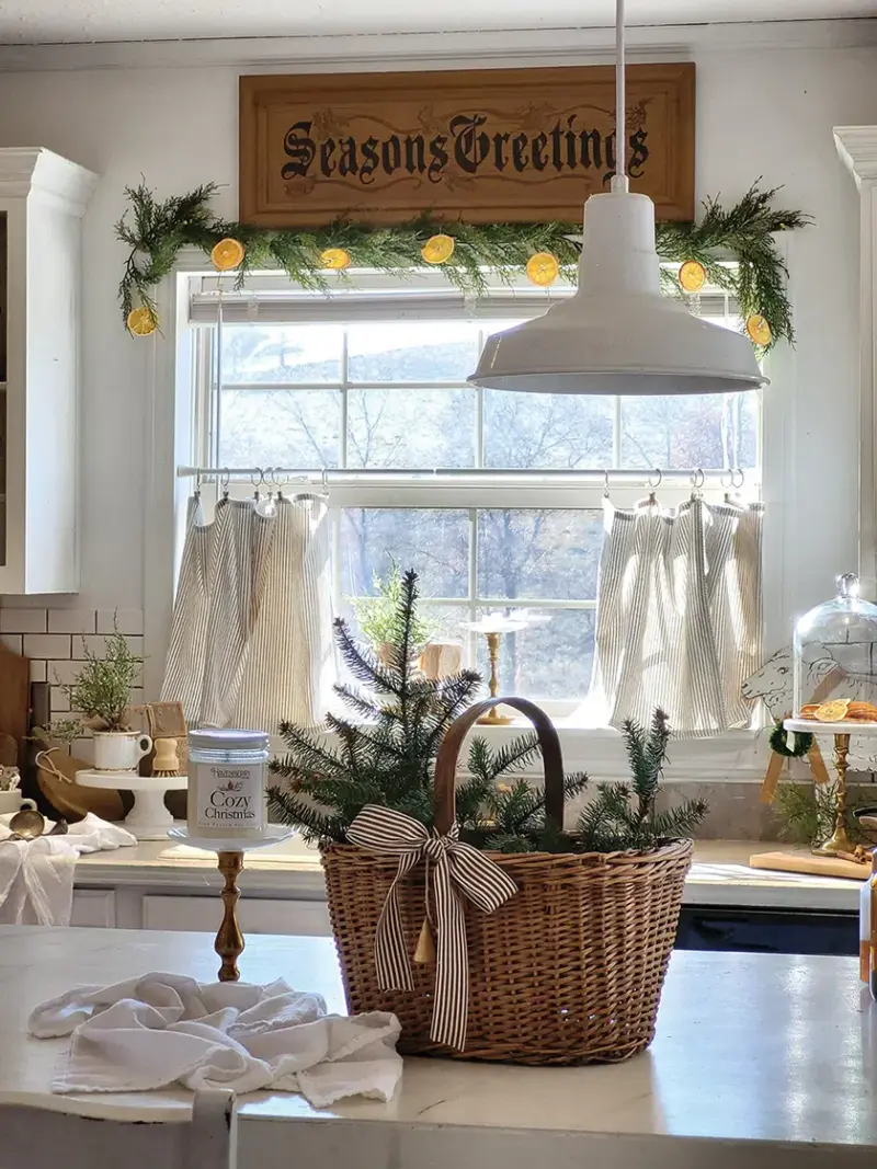 wicker basket with pine branches from just outside and natural wreath with citrus rounds in neutral cottage kitchen