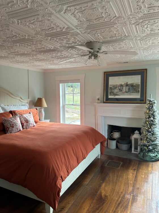 A bedroom with a Christmas tree and decorative ceiling tiles