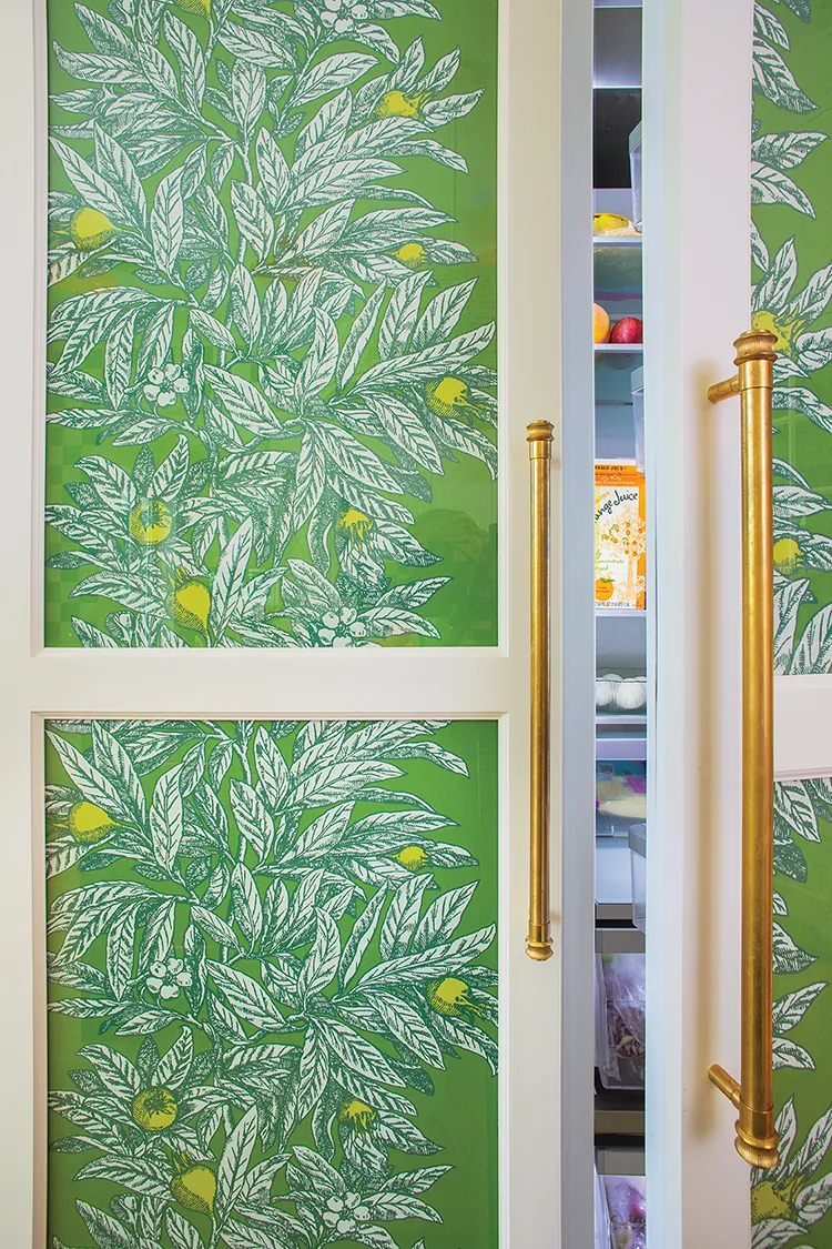 green botanical wallpaper covers fridge exterior bringing color to the kitchen