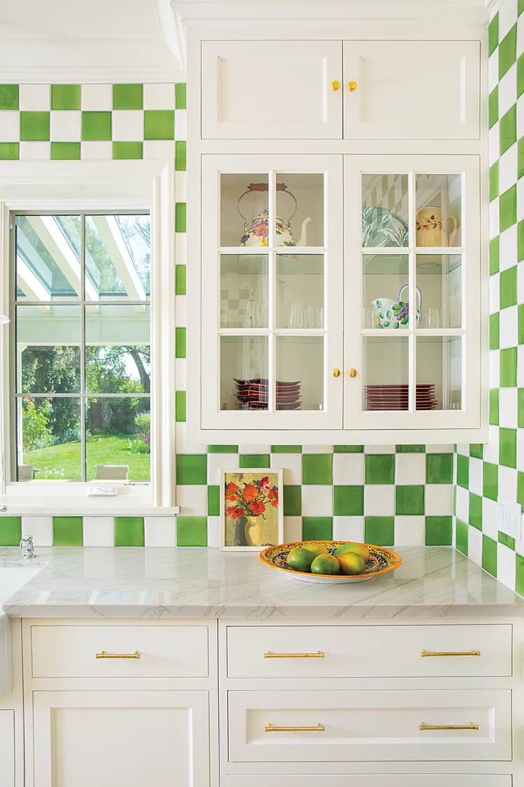 green and white tile and dish collection bring color to the kitchen