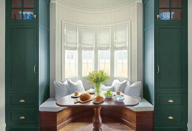 breakfast nook with bay windows and deep green cabinetry in Project House Utah