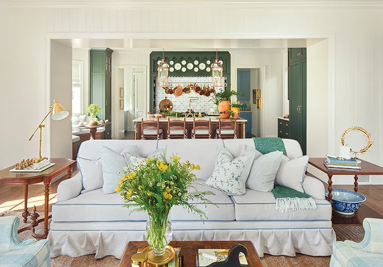 white couch with blue borders with view to kitchen with deep green cabinetry in final reveal of Project House Utah