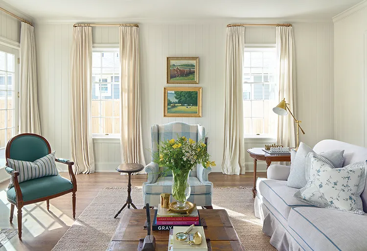 living room with landscape paintings, shiplap walls and cream colored curtains in Project House Utah