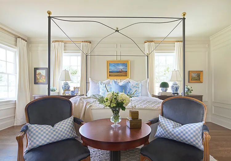 traditional style bedroom with landscape paintings and cream curtains and Bergere chairs in Project House Utah home