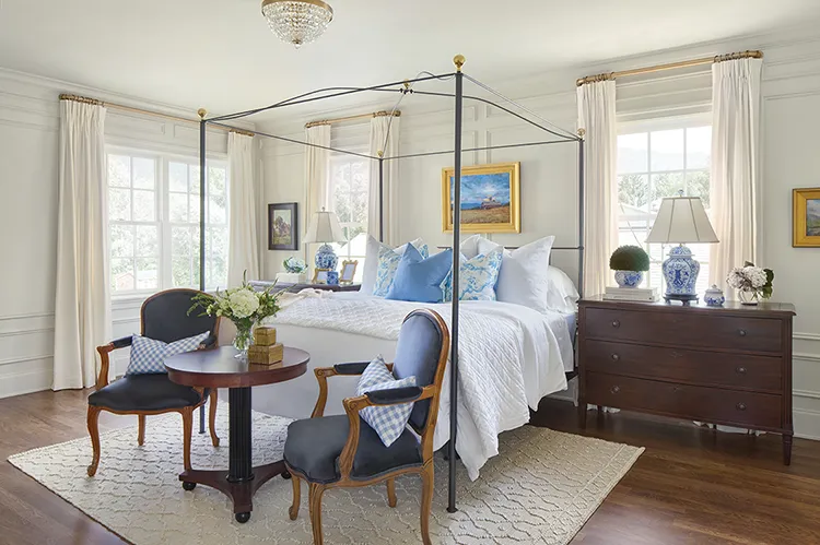 seating area at the foot of bed with canopy bedframe in Project House Utah