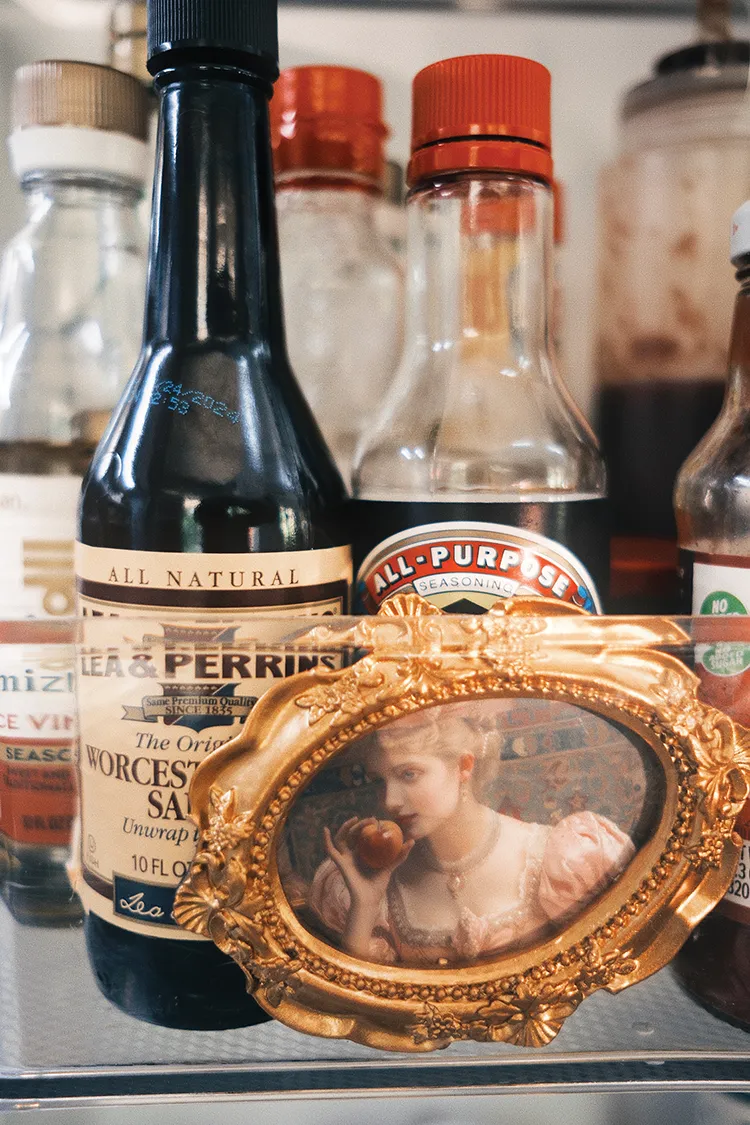 framed vintage portrait among condiments on refrigerator shelf