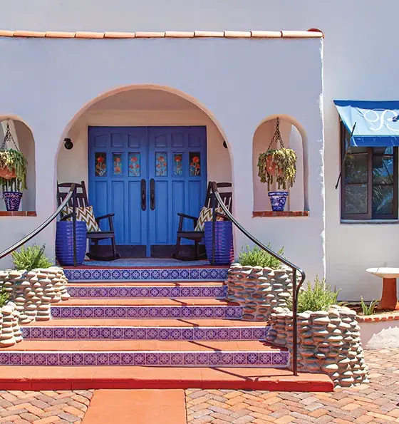 blue and white tiles lining staircase in entryway to renovated Spanish bungalow