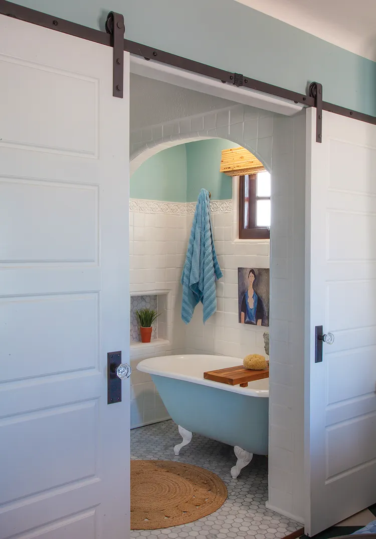 clawfoot tub with jute rug in cottage bathroom