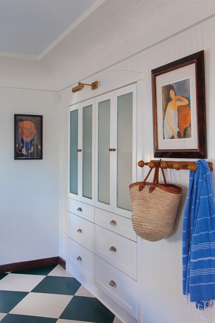 bathroom cabinetry and beadboard with framed art