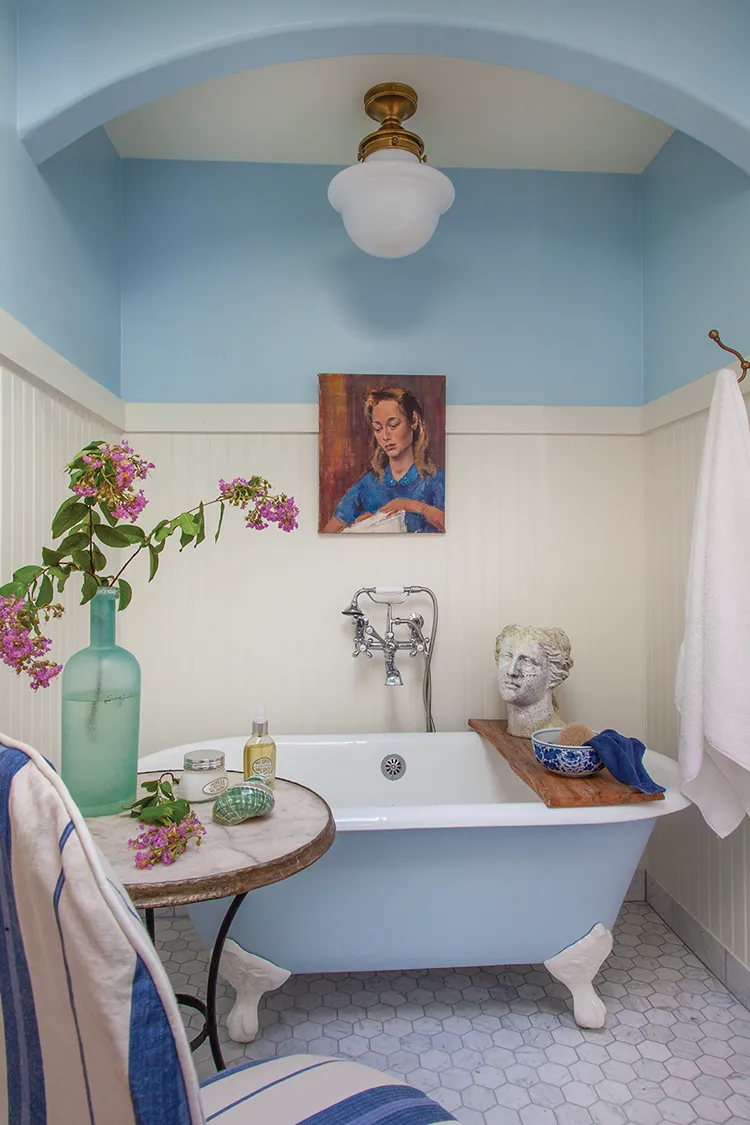 blue clawfoot tub in blue and white bathroom