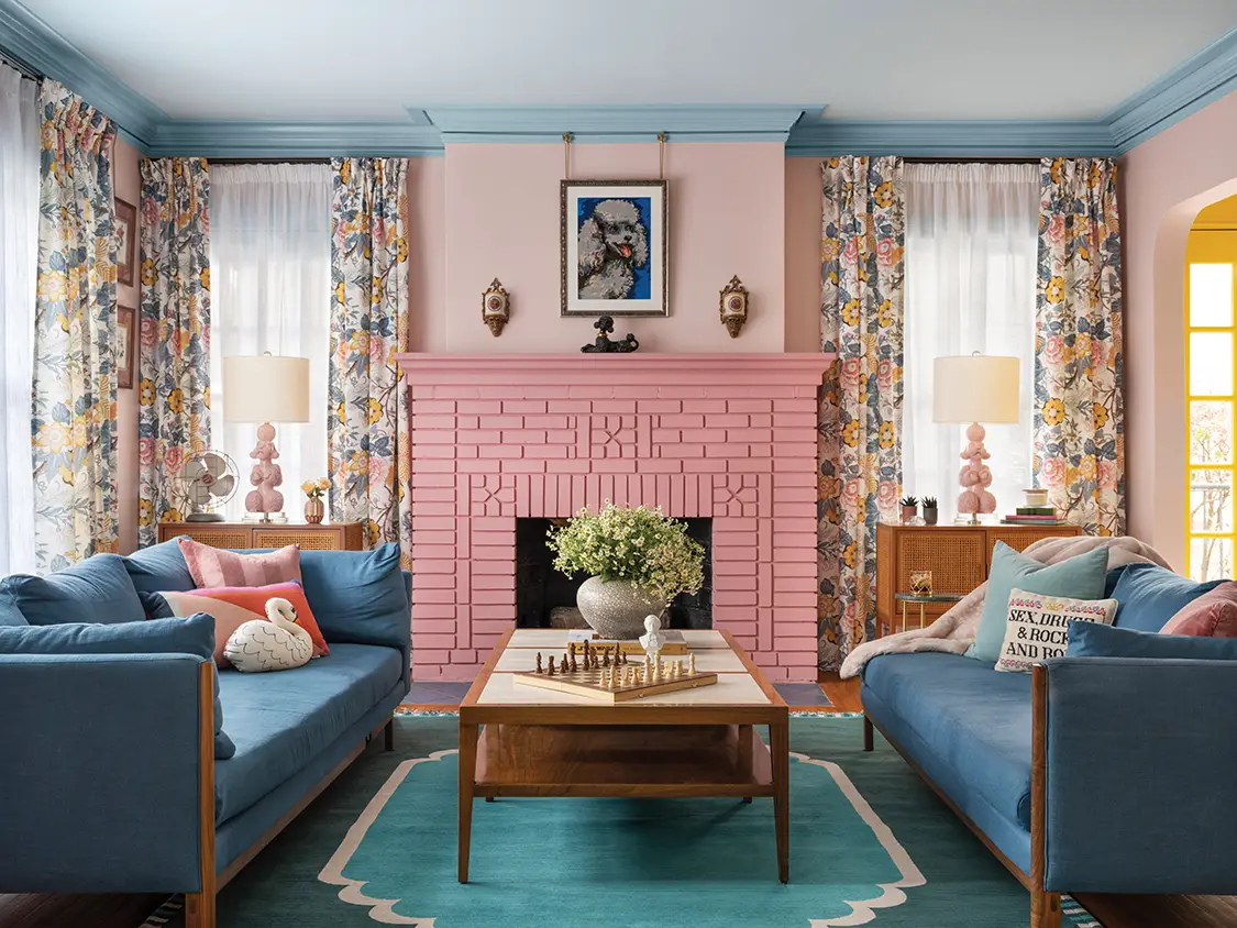 living room with floral curtains and pink brick fireplace