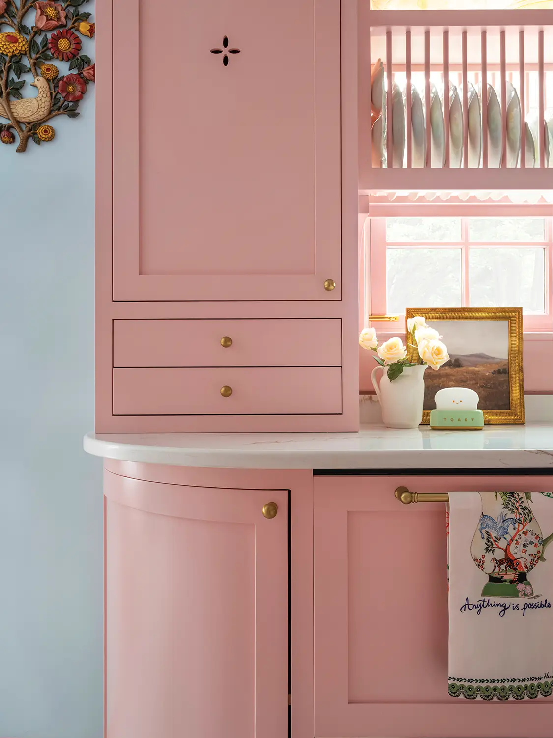 pink cabinetry with built-in plate storage in renovated 1930 Tudor home